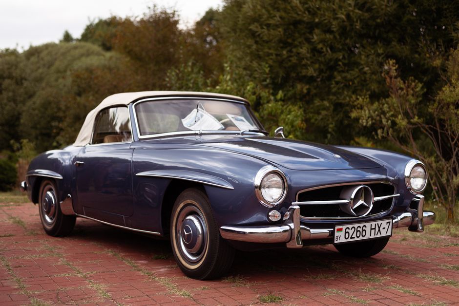 A beautifully preserved blue Mercedes 190SL convertible parked outdoors, showcasing classic elegance.